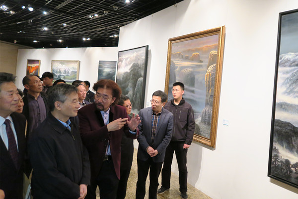 冯庆为罗富和介绍油画作品。